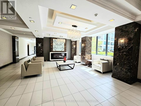 A spacious living room with a chandelier, a sofa set, and a coffee table.