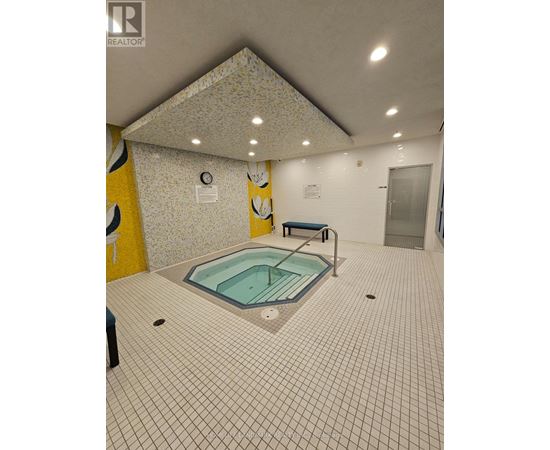 A small indoor pool with a bench.
