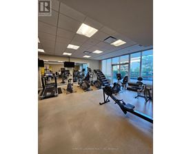 A gym with a variety of equipment including treadmills, weights, and exercise machines.