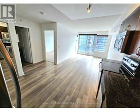 A kitchen with a black counter top and wooden floors.