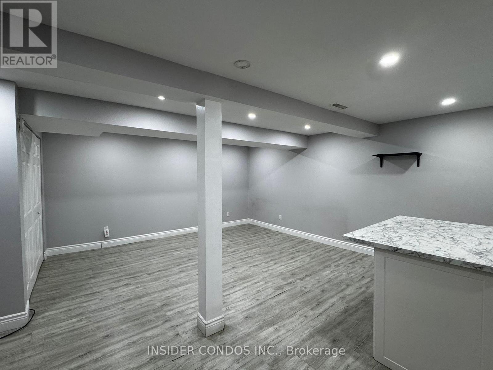 A spacious room with a marble countertop and wooden flooring.