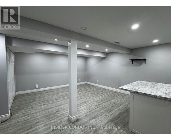A spacious room with a marble countertop and wooden flooring.