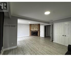 A spacious living room with a fireplace and wood flooring.