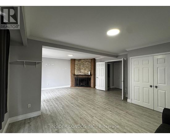 A spacious living room with a fireplace and wood flooring.