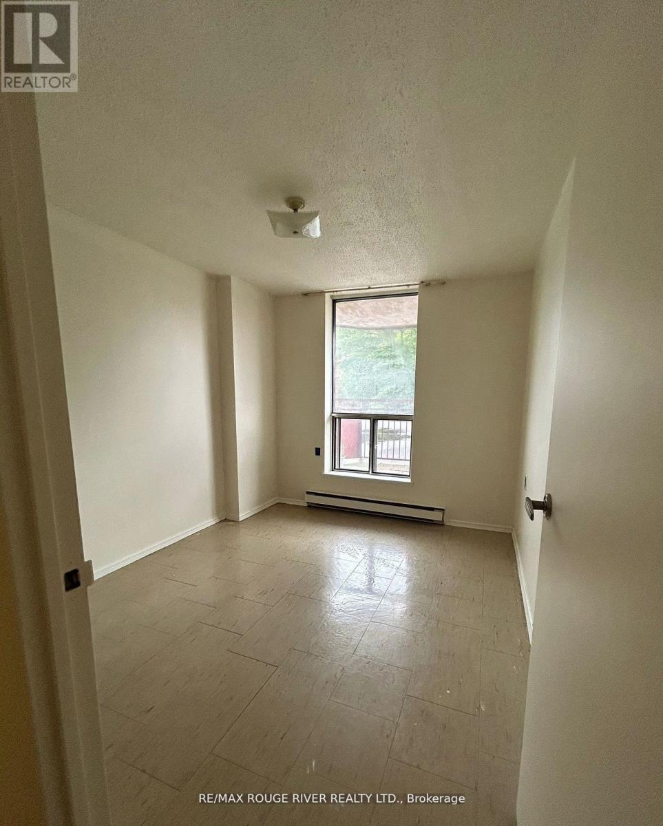 A spacious room with a window and tiled floor.