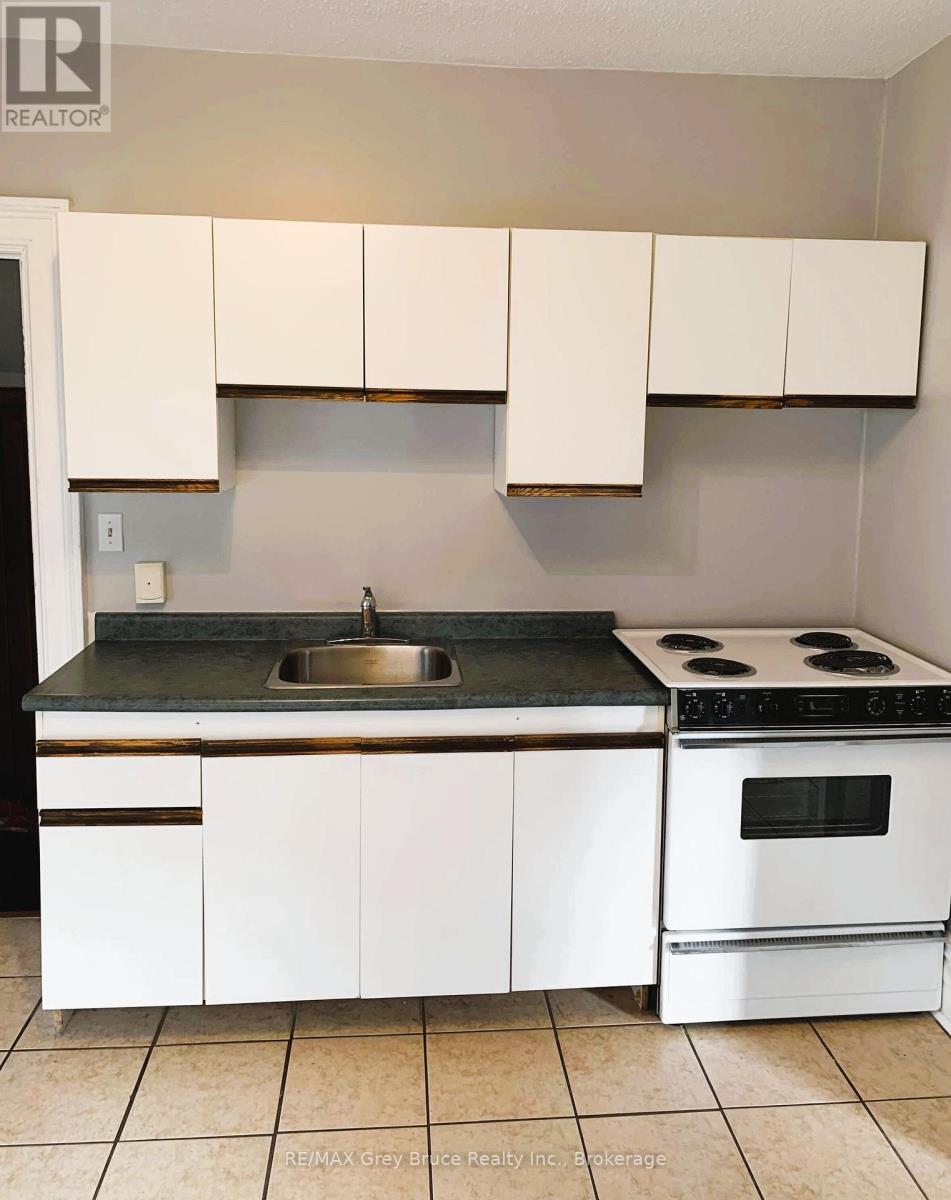 A kitchen with white cabinets and a black counter top.