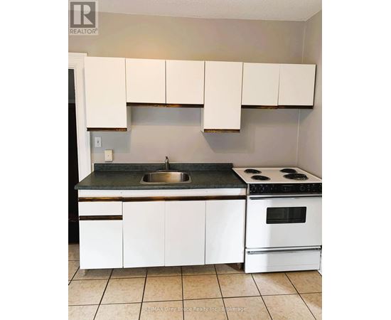 A kitchen with white cabinets and a black counter top.