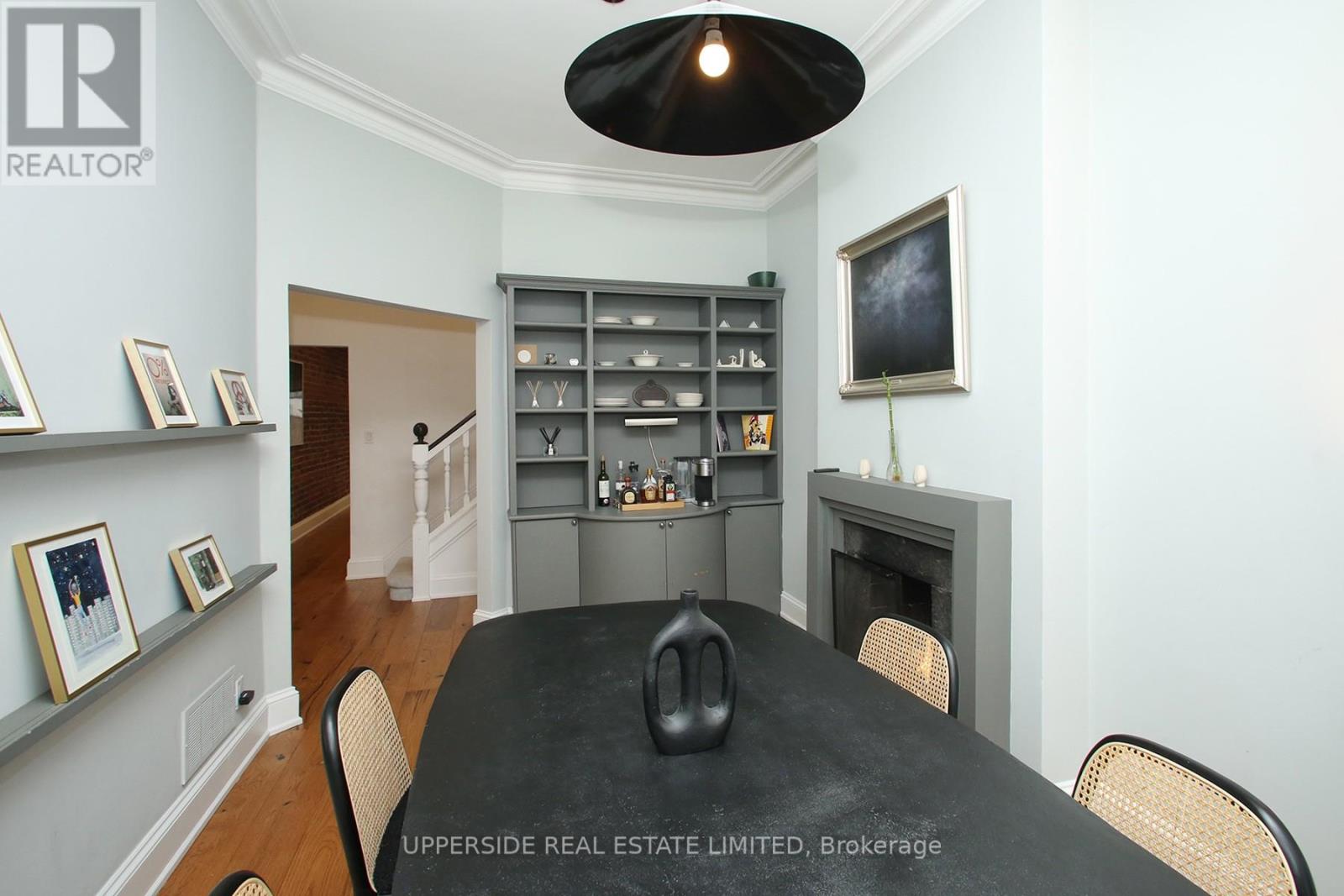 A dining room with a black table and chairs.