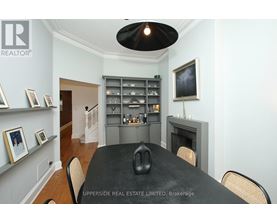 A dining room with a black table and chairs.