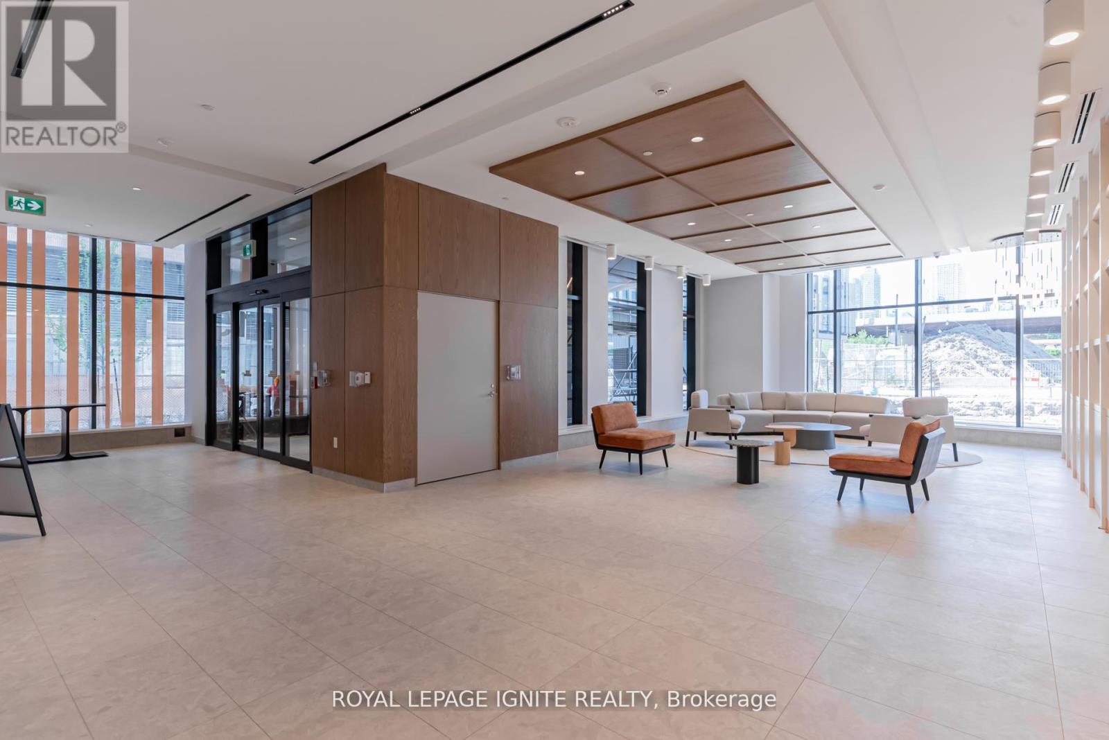 A spacious waiting area with wooden furniture and a glass wall.