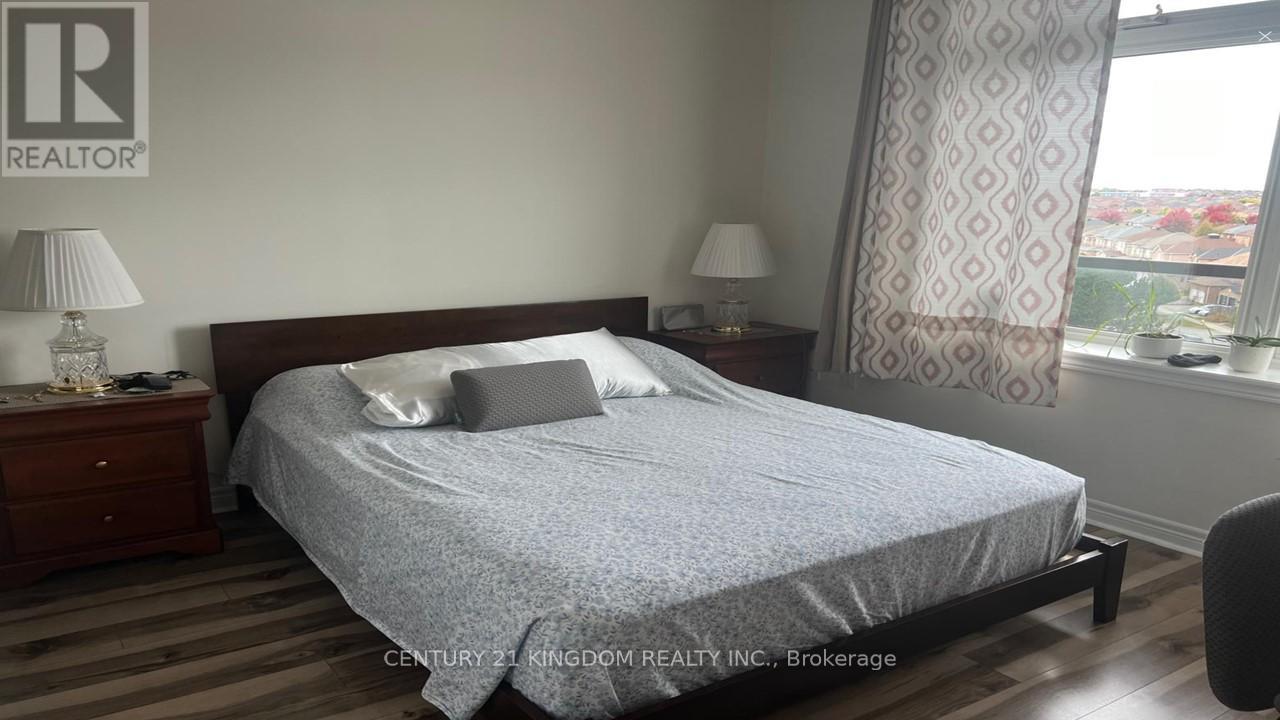 A bedroom with a bed, nightstands, and a window.