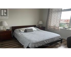 A bedroom with a bed, nightstands, and a window.