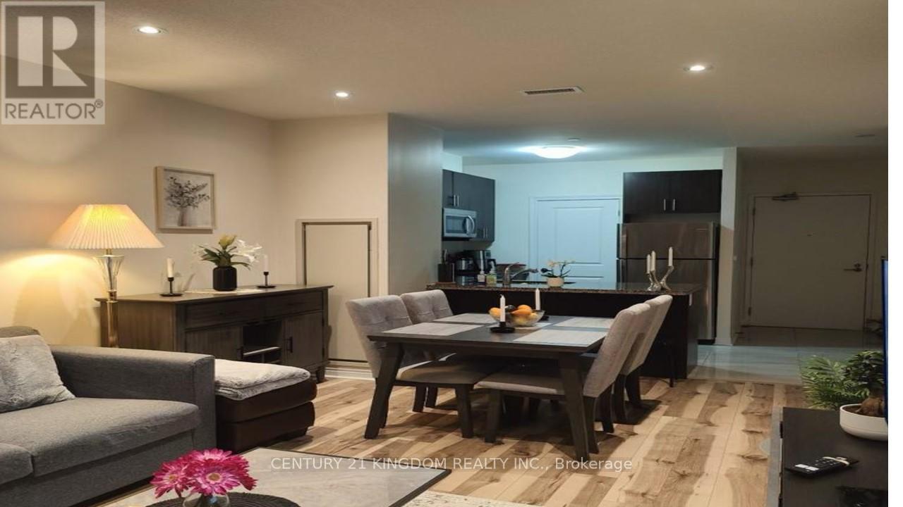 A well-lit living room with a grey sofa, a wooden coffee table, and a dining table set for two.
