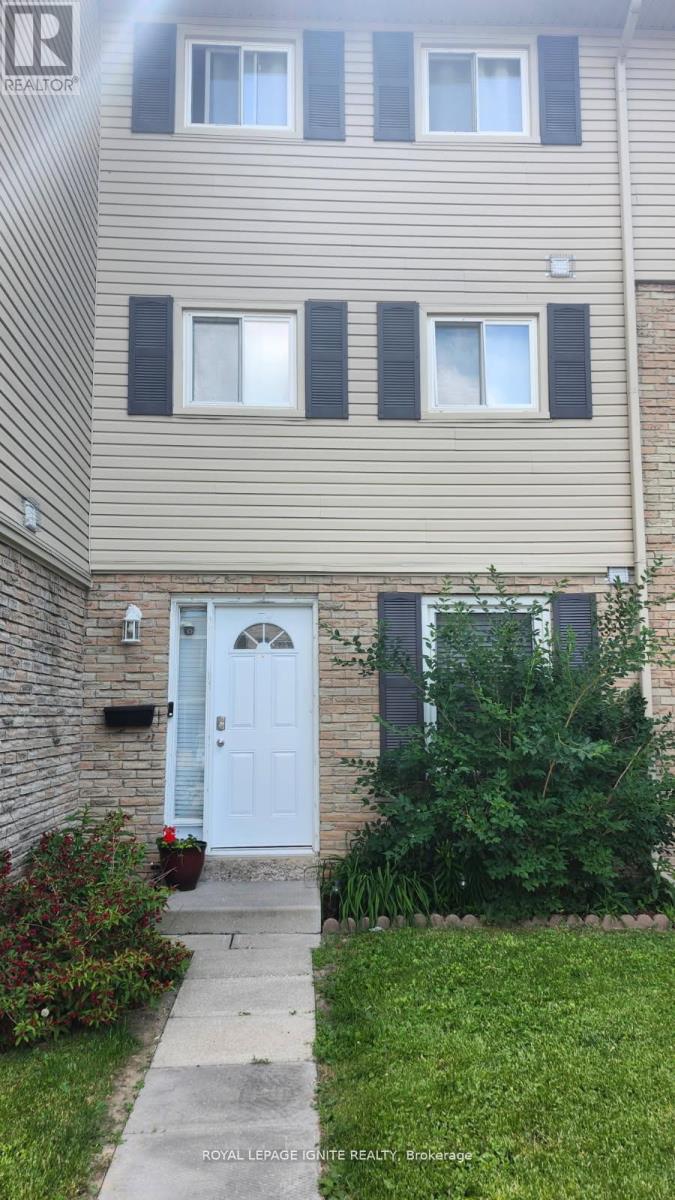 A building with a white door and windows with black shutters.