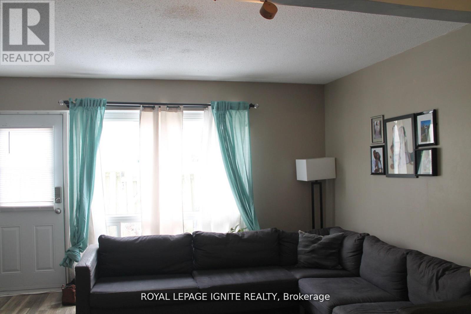 A living room with a couch and a fan.