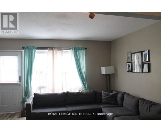 A living room with a couch and a fan.