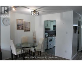 A dining room with a glass table and chairs.