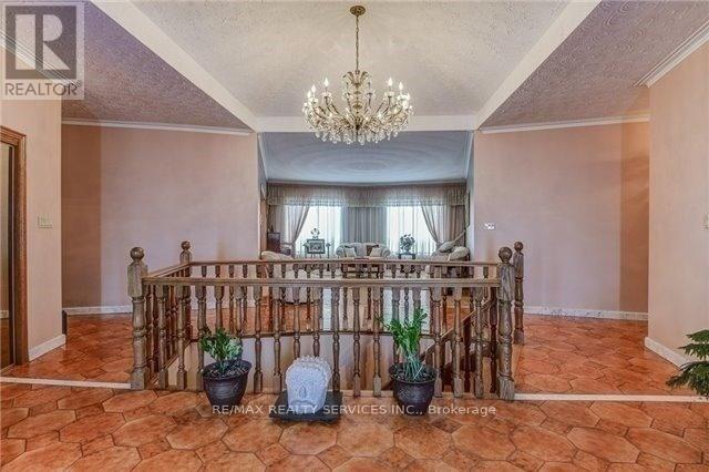 A room with a chandelier, a bed with a metal frame, and potted plants.