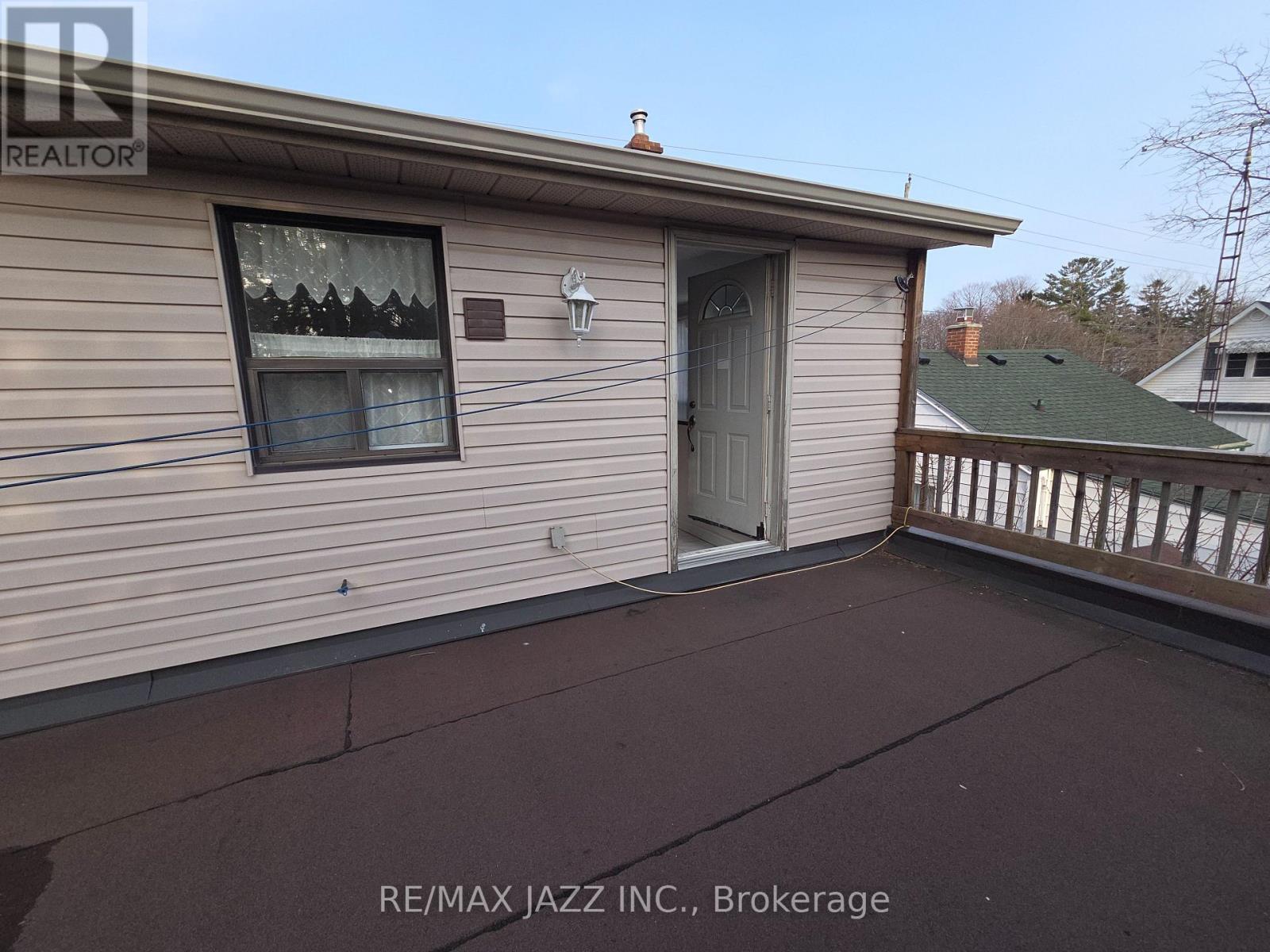 A house with a balcony and a window is for sale.