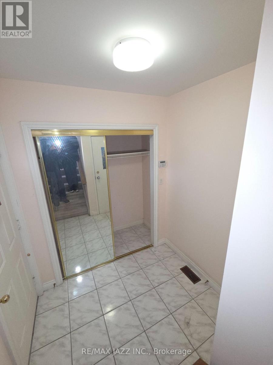 A hallway with a mirrored doorway leading to another room.