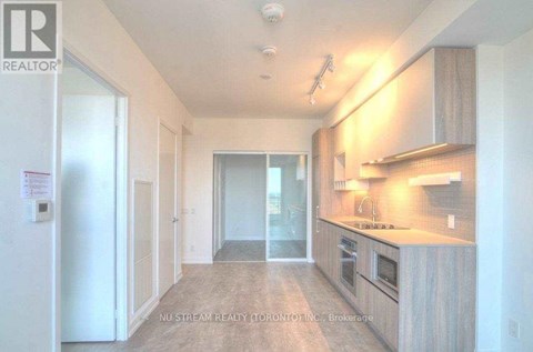 A kitchen area with a sink, stove and cabinets.