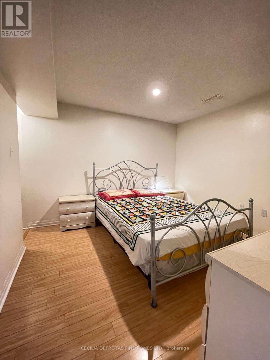 A bedroom with a metal frame bed and wooden flooring.