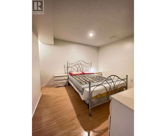 A bedroom with a metal frame bed and wooden flooring.