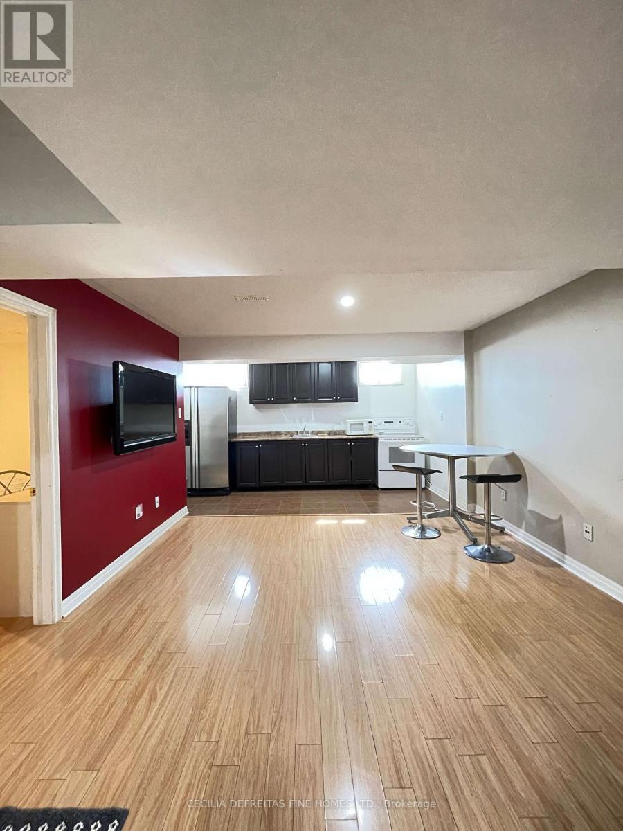 A living room with a wooden floor and a red wall.
