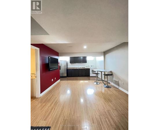 A living room with a wooden floor and a red wall.