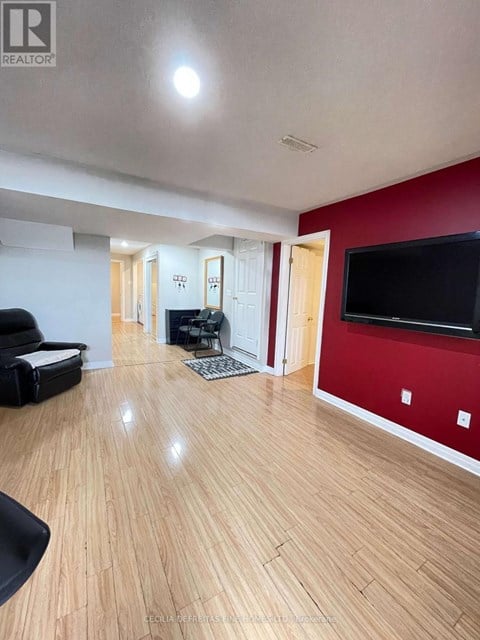 A living room with a black chair and a television.