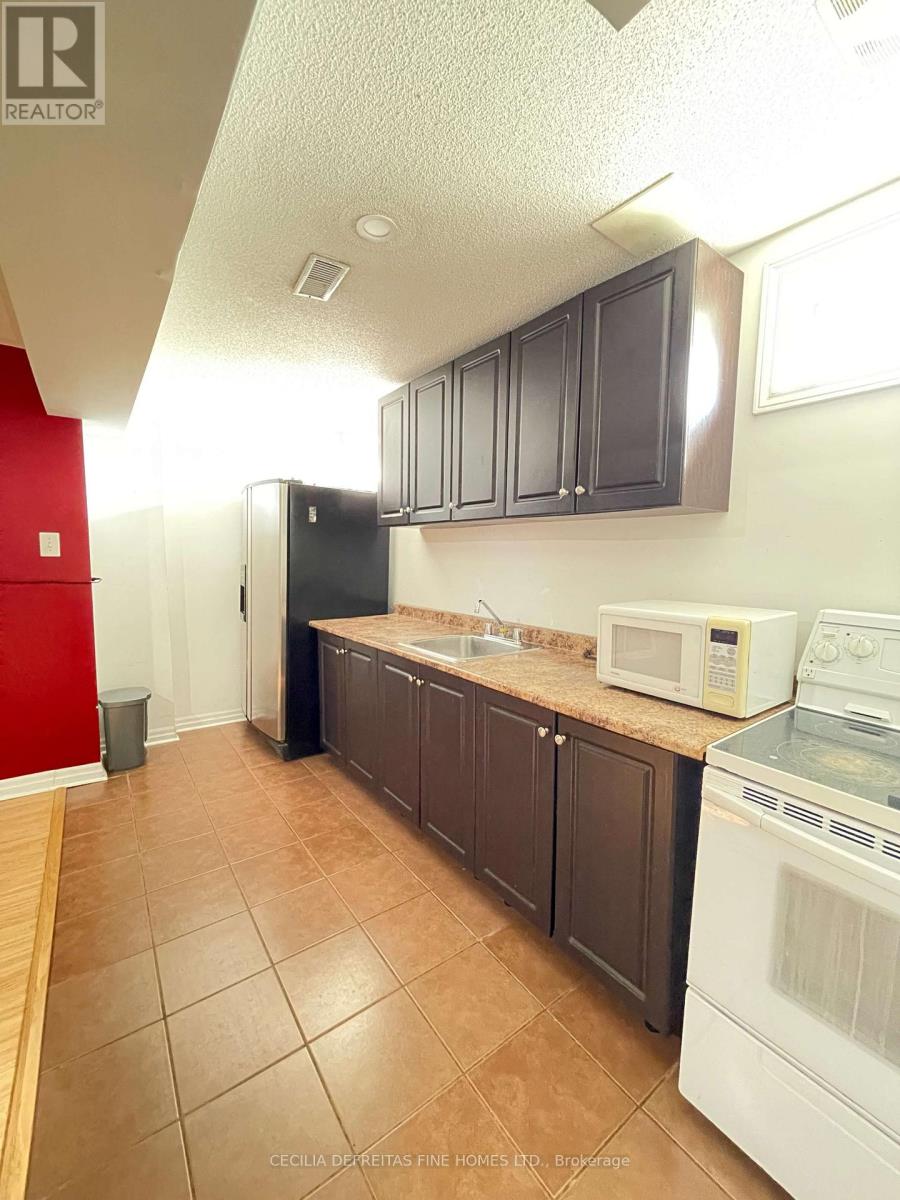 A kitchen with brown cabinets and a white fridge.