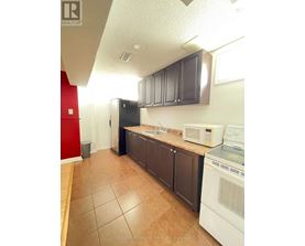 A kitchen with brown cabinets and a white fridge.