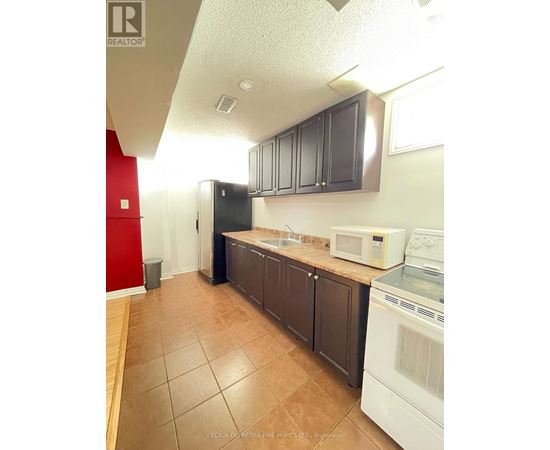 A kitchen with brown cabinets and a white fridge.