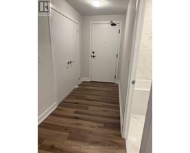 A hallway with wood floors and white walls.