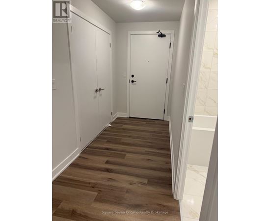 A hallway with wood floors and white walls.