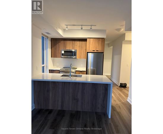 A modern kitchen with a wooden countertop and stainless steel appliances.