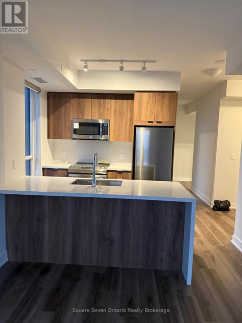 A modern kitchen with a wooden countertop and stainless steel appliances.