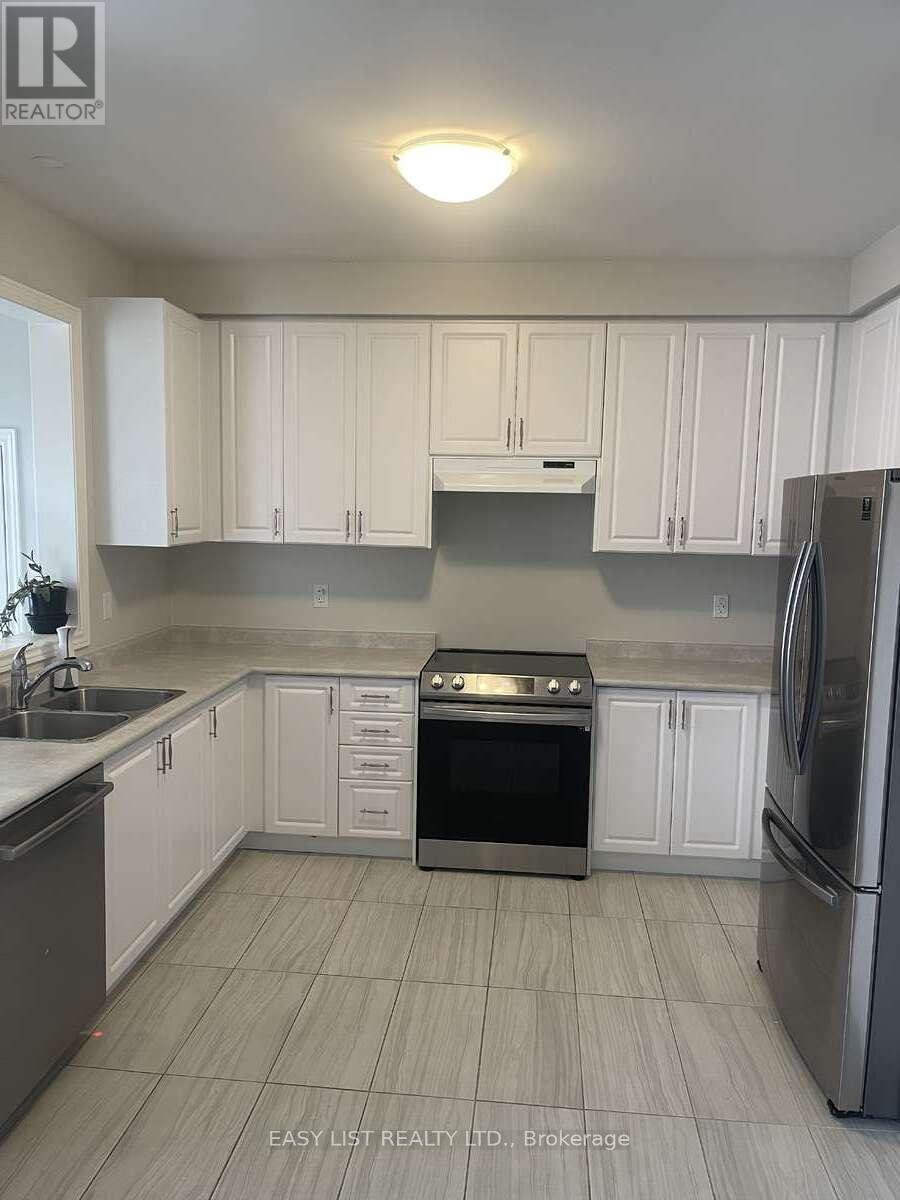A kitchen with white cabinets and a stainless steel refrigerator.