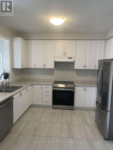 A kitchen with white cabinets and a stainless steel refrigerator.