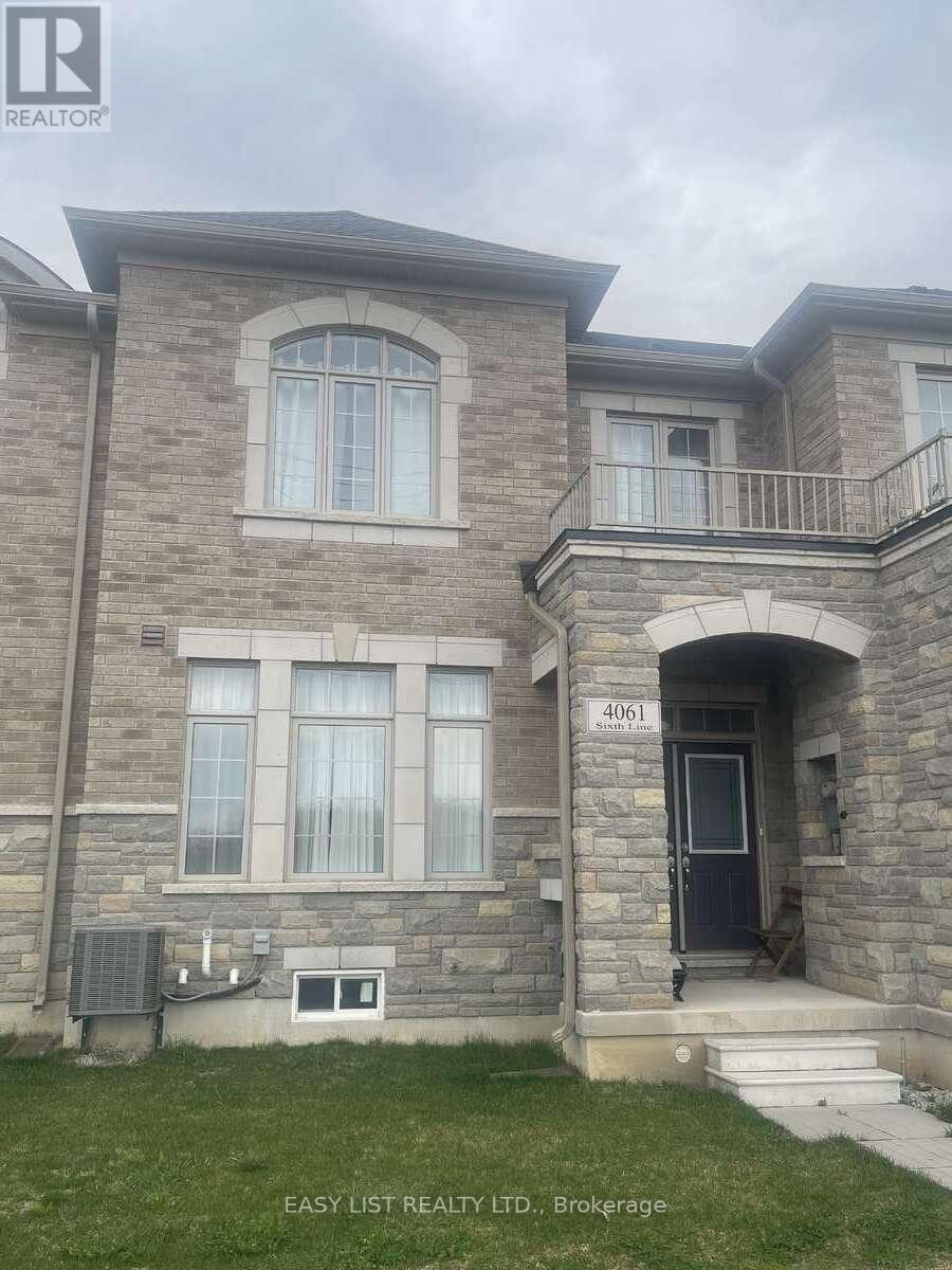 A stone house with a black door and a balcony.