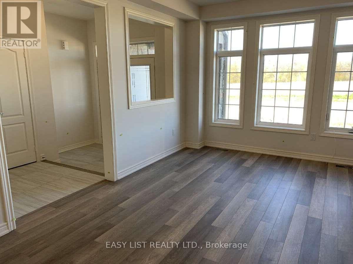 A room with wooden flooring and a large window.