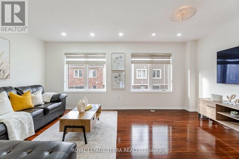 A living room with a black leather couch and a coffee table.