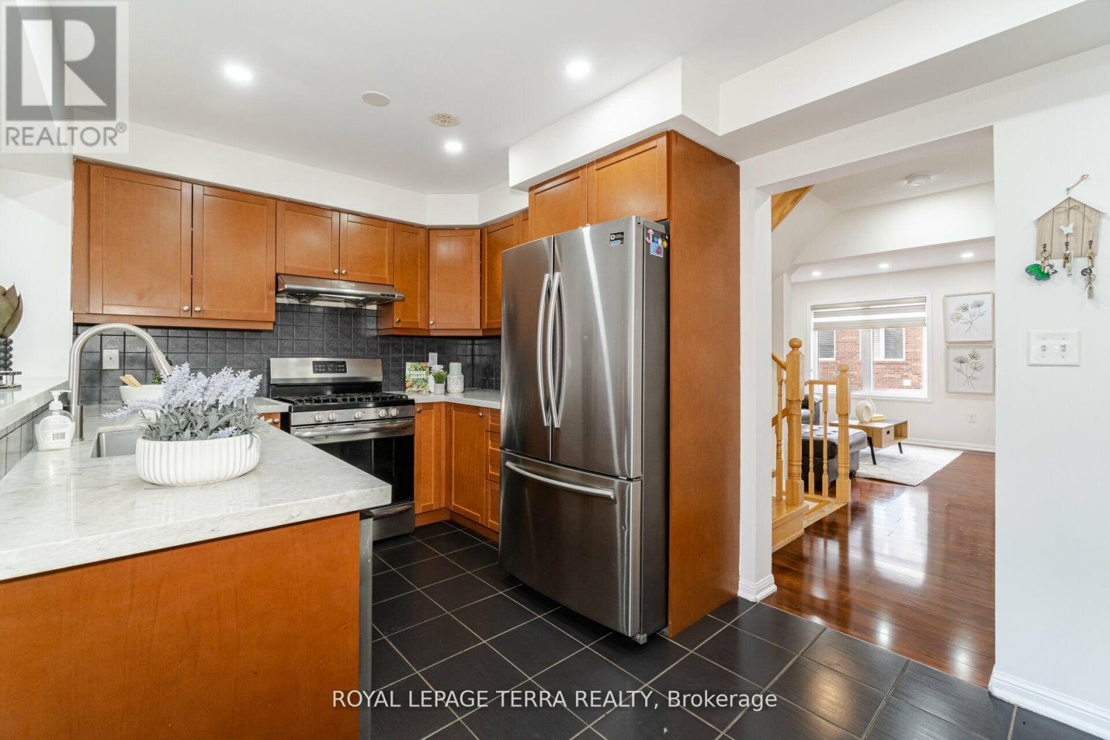 A kitchen with wooden cabinets and a stainless steel refrigerator.