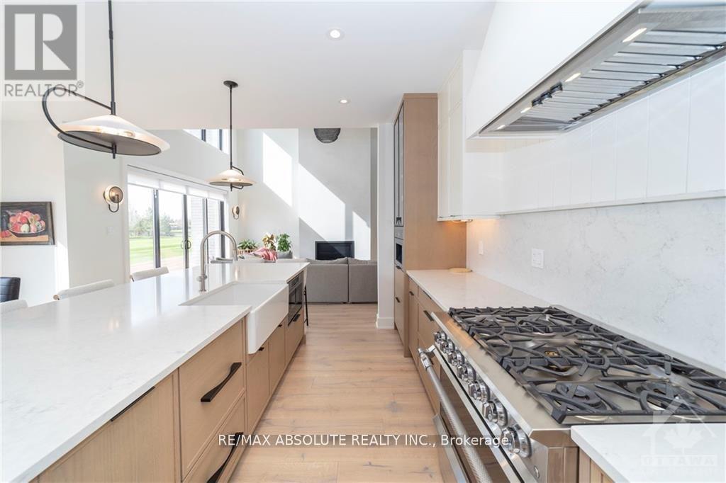 A modern kitchen with a large island and stove top.