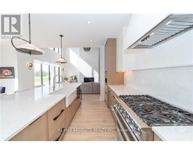 A modern kitchen with a large island and stove top.