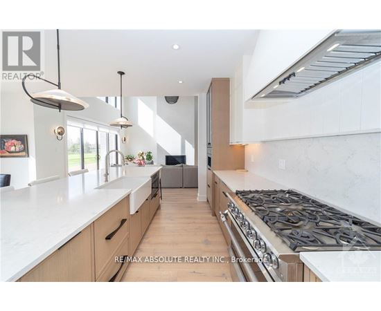 A modern kitchen with a large island and stove top.