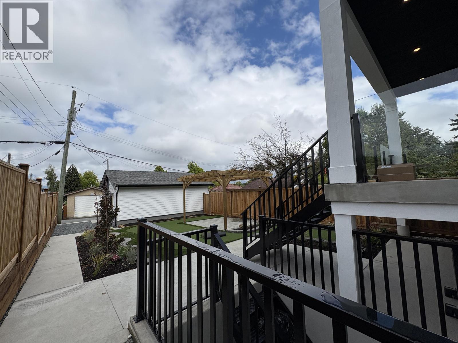 A balcony with a black railing overlooks a residential area.