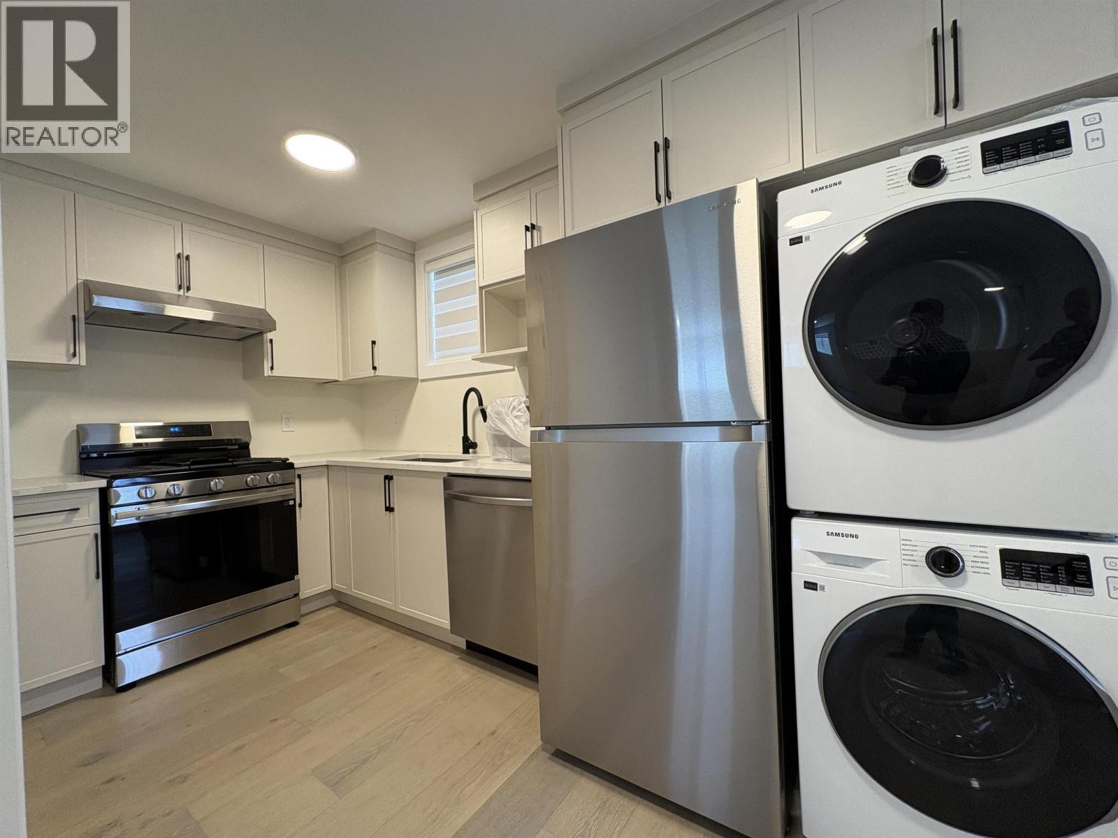 A modern kitchen with a washer and dryer built into the cabinetry.