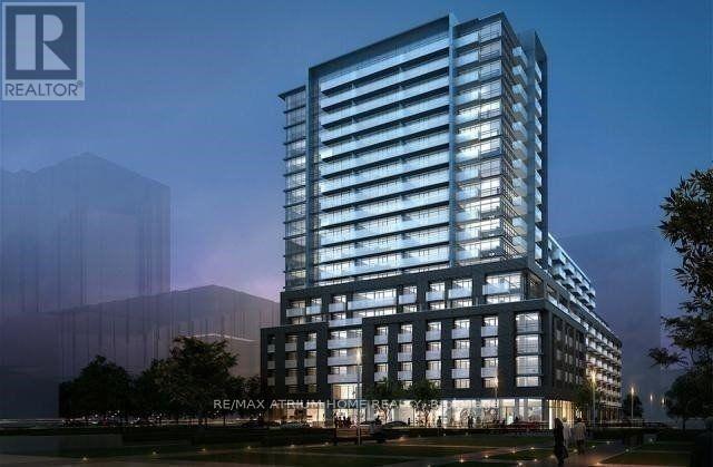 A modern building with a glass facade is illuminated at night.