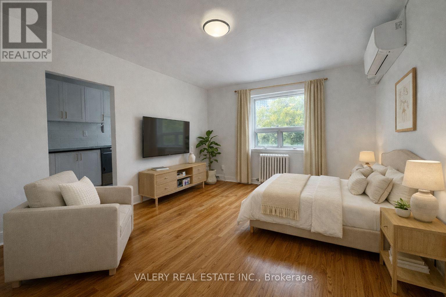 A bedroom with a bed, couch, and television.